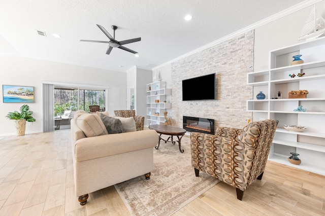 living area featuring visible vents, ornamental molding, a textured ceiling, a stone fireplace, and ceiling fan