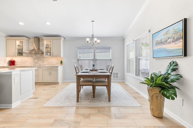 dining area with visible vents, an inviting chandelier, light wood-style flooring, and crown molding