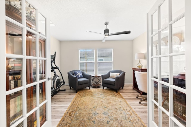 office area with a textured ceiling, light wood-style flooring, french doors, and ceiling fan