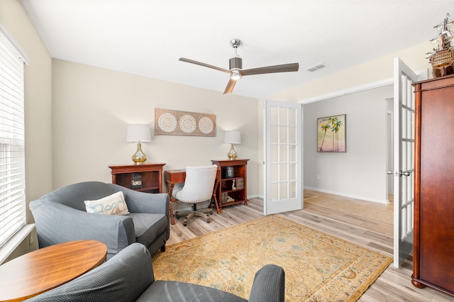 interior space with visible vents, baseboards, french doors, wood finished floors, and a ceiling fan