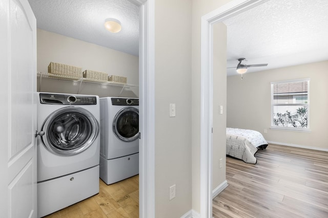 laundry room featuring a ceiling fan, laundry area, light wood-style floors, a textured ceiling, and washing machine and dryer