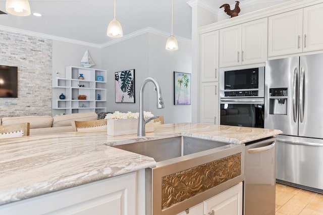 kitchen featuring light wood-style floors, appliances with stainless steel finishes, crown molding, and hanging light fixtures