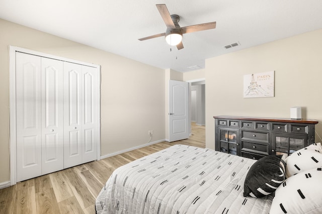 bedroom with light wood-type flooring, visible vents, a closet, baseboards, and ceiling fan