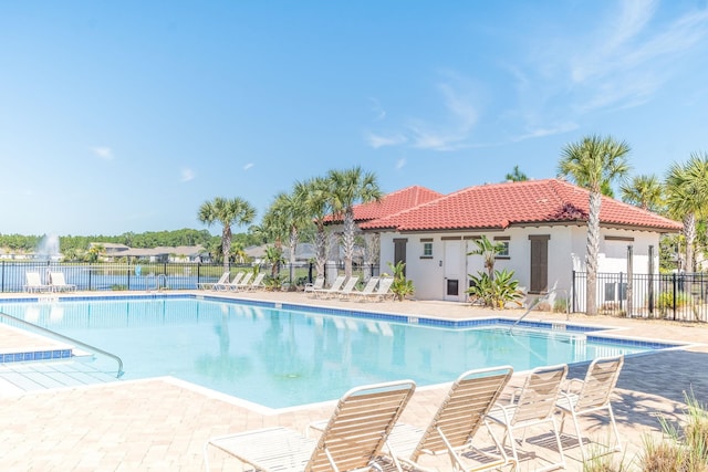 pool with a patio and fence