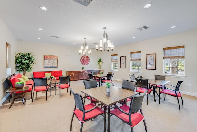 dining area featuring visible vents, light colored carpet, and an inviting chandelier