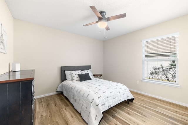 bedroom with baseboards, ceiling fan, and light wood finished floors