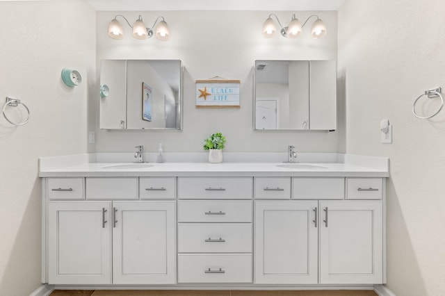 bathroom with double vanity, baseboards, and a sink