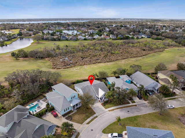 drone / aerial view with view of golf course, a water view, and a residential view