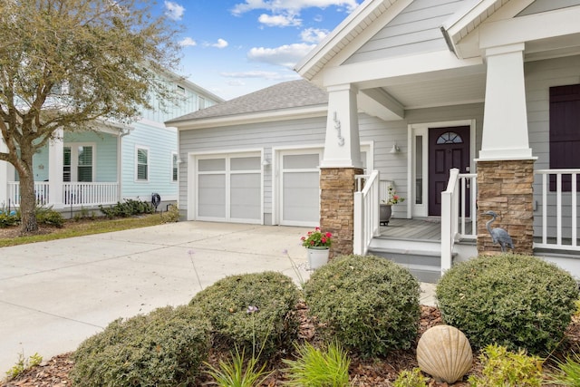 exterior space featuring a garage, concrete driveway, a porch, and roof with shingles