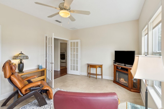 sitting room featuring french doors, washer / clothes dryer, visible vents, ceiling fan, and baseboards