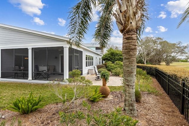 view of yard featuring a patio area, fence, and a sunroom