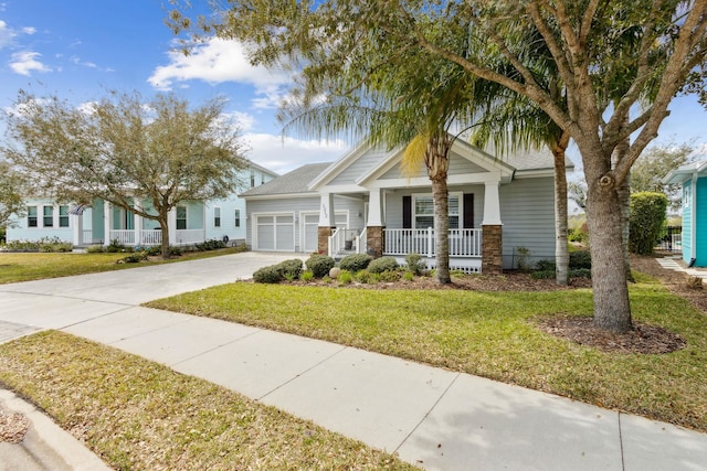 craftsman inspired home featuring covered porch, driveway, a front lawn, and a garage