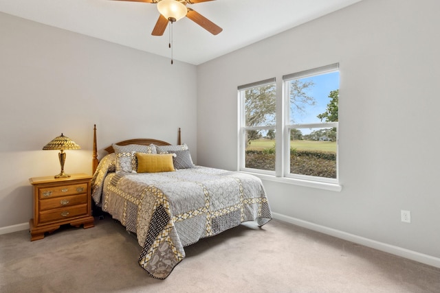 bedroom with ceiling fan, baseboards, and carpet flooring