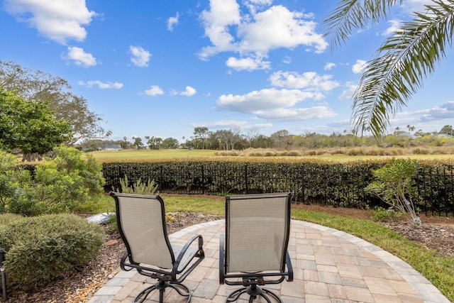 view of patio featuring a rural view and fence