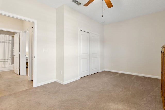 unfurnished bedroom with light carpet, baseboards, visible vents, and a closet