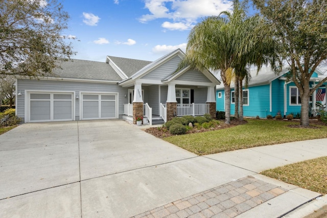 view of front of house featuring roof with shingles, a porch, concrete driveway, an attached garage, and a front yard