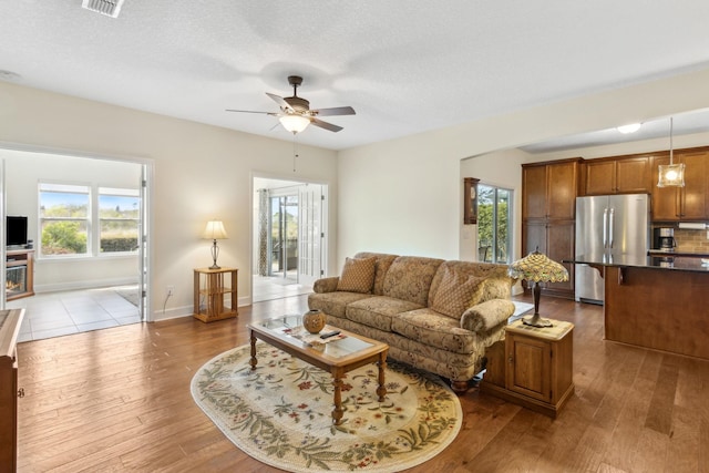 living room featuring hardwood / wood-style floors, plenty of natural light, and a ceiling fan