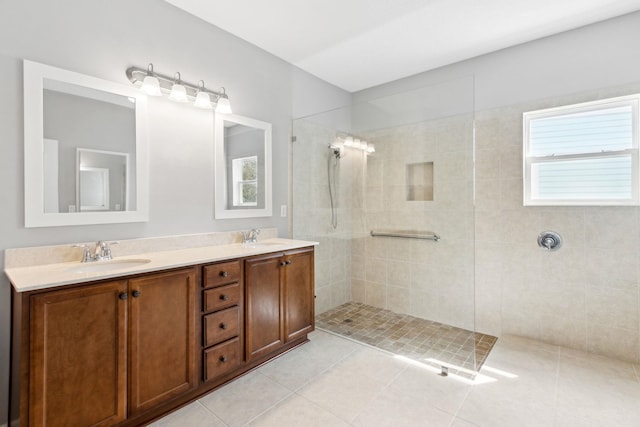 bathroom featuring double vanity, a walk in shower, a sink, and tile patterned floors