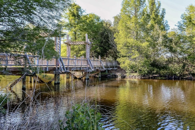 view of dock with a water view and a pergola