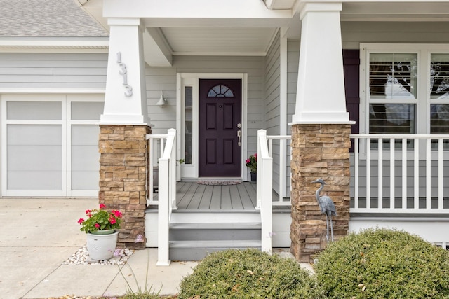 property entrance with a garage, stone siding, and roof with shingles