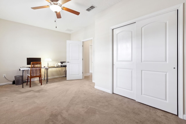 office featuring carpet, visible vents, ceiling fan, and baseboards