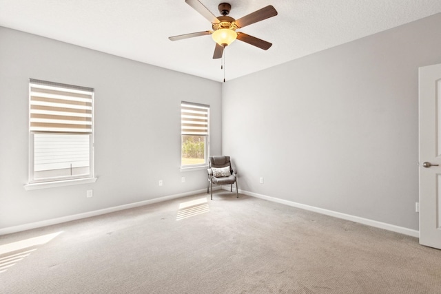 spare room with a ceiling fan, carpet flooring, and baseboards