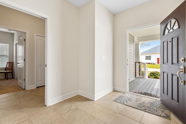 foyer with light tile patterned flooring and baseboards