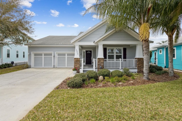 craftsman-style home with a porch, a front yard, concrete driveway, and an attached garage