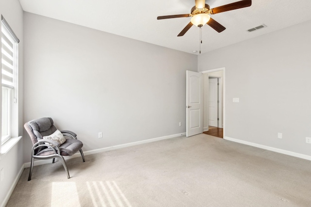 unfurnished room with light carpet, ceiling fan, visible vents, and baseboards