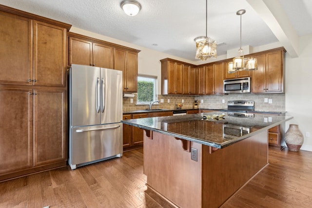 kitchen featuring a breakfast bar, dark wood-style floors, brown cabinets, and stainless steel appliances