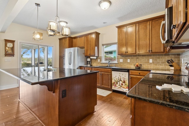 kitchen with appliances with stainless steel finishes, brown cabinets, and a sink