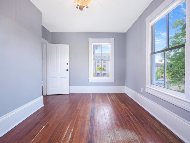 empty room featuring dark wood-type flooring and plenty of natural light