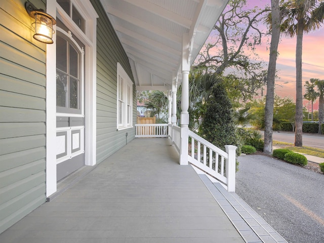 patio terrace at dusk featuring covered porch