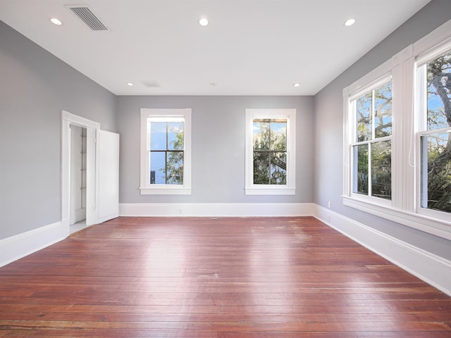 unfurnished room featuring dark wood-type flooring and plenty of natural light