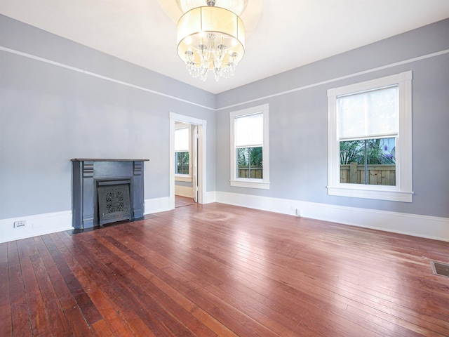 unfurnished living room featuring wood-type flooring and a notable chandelier