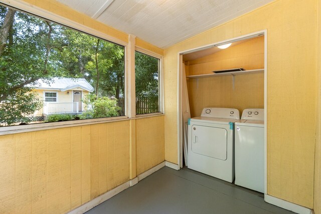 washroom with wooden walls and independent washer and dryer