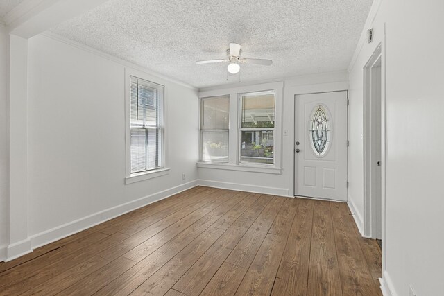 foyer with wood-type flooring, a textured ceiling, and ceiling fan