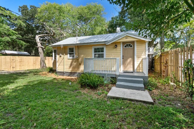 view of front of home with a deck and a front yard