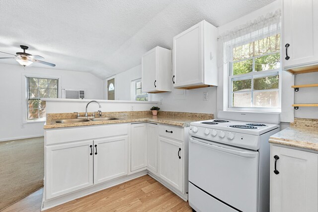 kitchen featuring kitchen peninsula, electric stove, plenty of natural light, and lofted ceiling