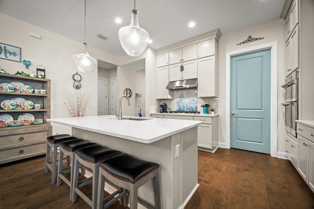 118 Lamego Ln, Saint Augustine, FL 32095 - kitchen with a breakfast bar, under cabinet range hood, visible vents, stainless steel appliances, and a sink
