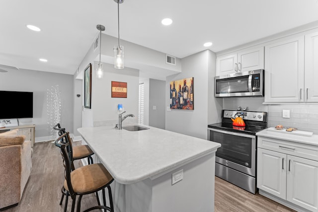 7 Andalusia Ct, Saint Augustine, FL 32086 - kitchen featuring stainless steel appliances, open floor plan, a breakfast bar, white cabinets, and recessed lighting