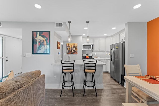 7 Andalusia Ct, Saint Augustine, FL 32086 - kitchen featuring appliances with stainless steel finishes, a peninsula, dark wood-style floors, white cabinetry, and recessed lighting