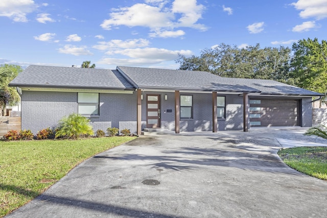 view of front of property with covered porch, a garage, and a front yard