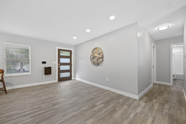 foyer featuring wood-type flooring and a textured ceiling