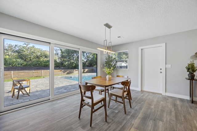 dining area featuring hardwood / wood-style floors and a textured ceiling