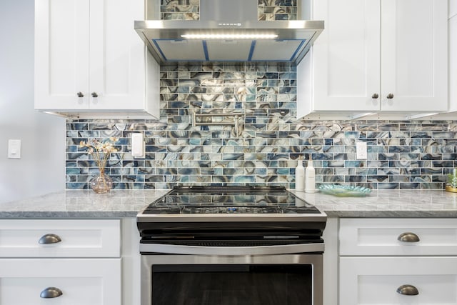50 Dufferin St, Saint Augustine, FL 32084 - kitchen featuring stainless steel range with electric stovetop, extractor fan, white cabinets, and backsplash