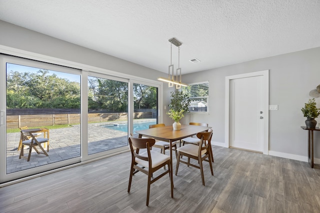 50 Dufferin St, Saint Augustine, FL 32084 - dining space with wood finished floors, a textured ceiling, and a chandelier