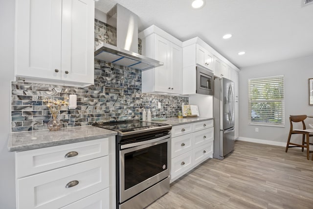 kitchen featuring white cabinets, wall chimney exhaust hood, light stone countertops, and stainless steel appliances