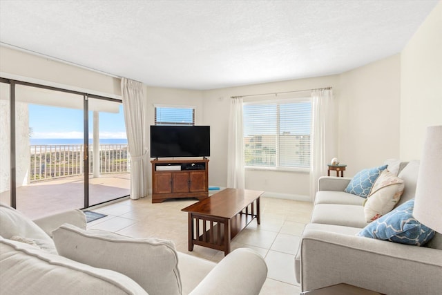 living area with a textured ceiling, tile patterned flooring, and a wealth of natural light