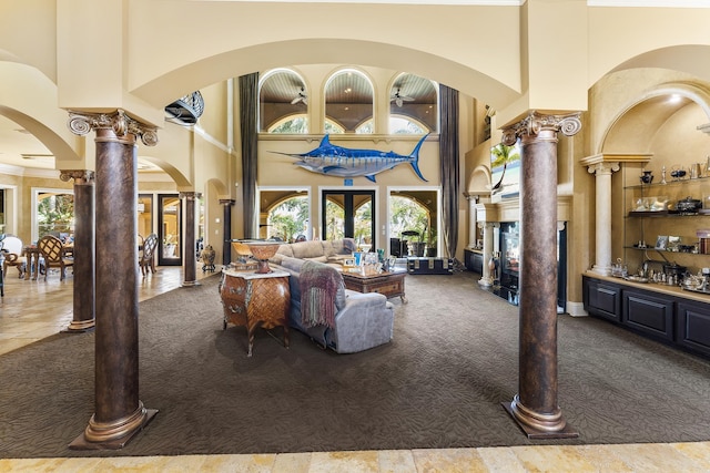 carpeted living room featuring ornate columns, french doors, and a high ceiling